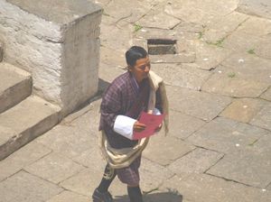 Bhutańczyk w stroju Go udaje sie do urzędu z dzongu