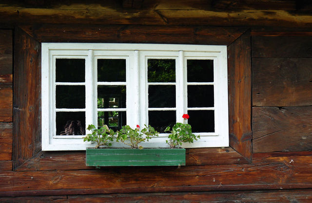 Wiejskie okienka z pelargoniami.