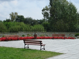 Plac i klomby kwiatowe przy pomniku.