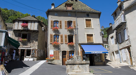 Chaudes aigues   kamieniczki przy wyasfaltowanym placu – Chaudes-Aigues, Francja