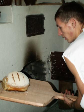 Mariusz Wądołowski wyjmuje upieczony chleb